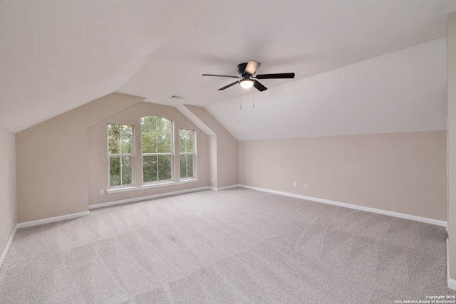 additional living space with ceiling fan, carpet flooring, visible vents, baseboards, and vaulted ceiling