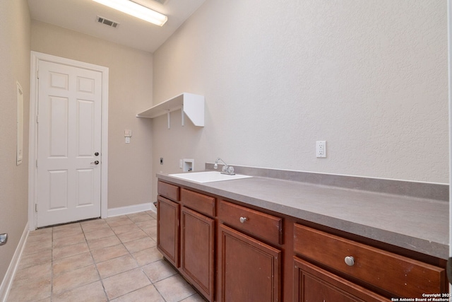 clothes washing area with washer hookup, light tile patterned floors, visible vents, hookup for an electric dryer, and a sink