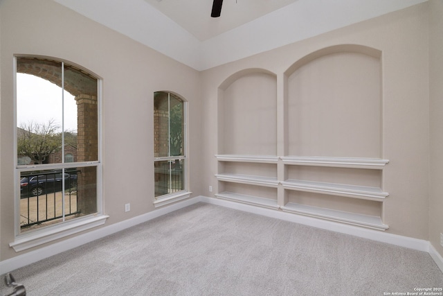 carpeted empty room with ceiling fan and baseboards