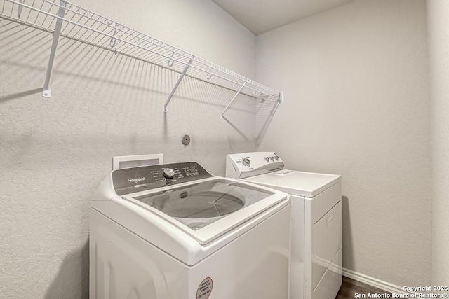 washroom featuring a textured wall, laundry area, independent washer and dryer, and baseboards