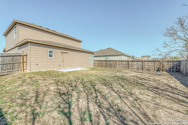 back of house with a yard, a patio, and a fenced backyard