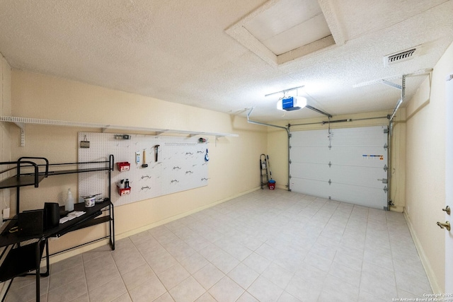 garage with baseboards, visible vents, and a garage door opener