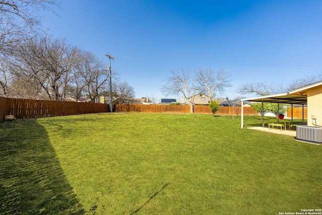 view of yard featuring a fenced backyard, a patio, and central AC unit