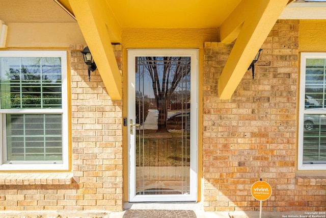 property entrance featuring brick siding