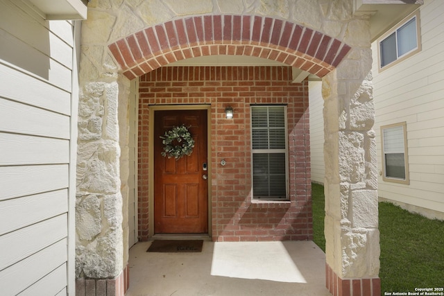 entrance to property featuring brick siding