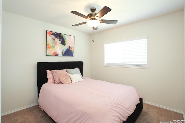 carpeted bedroom with ceiling fan and baseboards