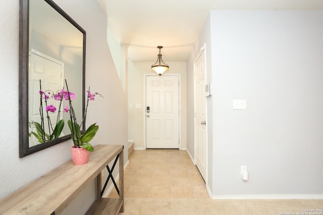 doorway to outside with light tile patterned flooring and baseboards