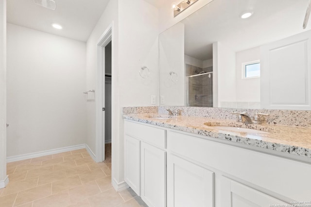 full bath with double vanity, a spacious closet, a stall shower, and a sink