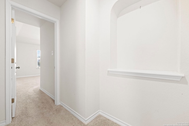 hall featuring carpet flooring and baseboards