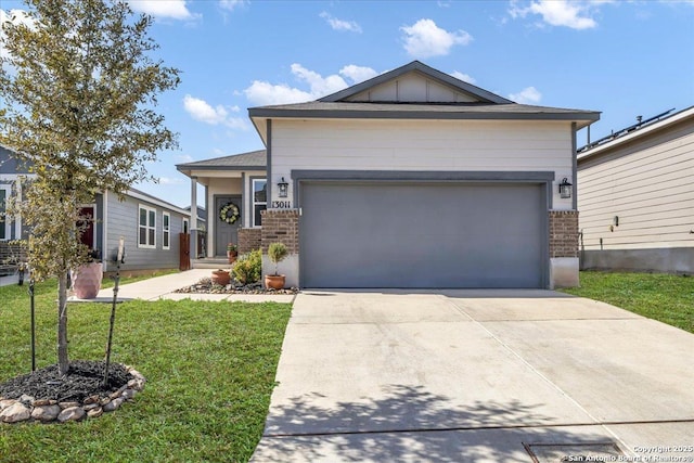 view of front of house featuring a garage, concrete driveway, a front lawn, board and batten siding, and brick siding