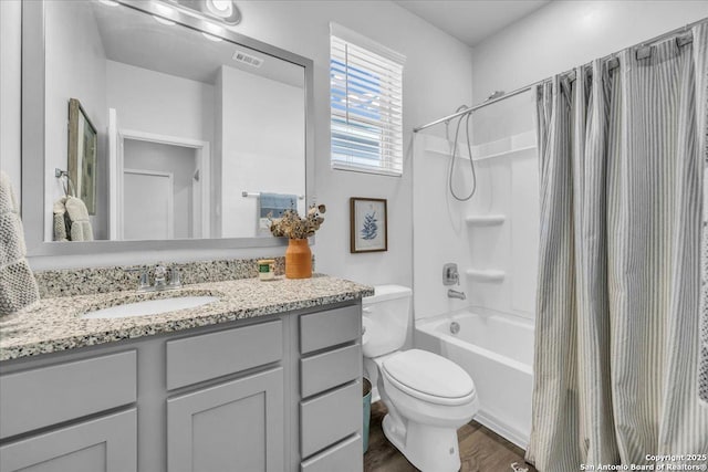 bathroom featuring shower / bath combo, visible vents, toilet, wood finished floors, and vanity