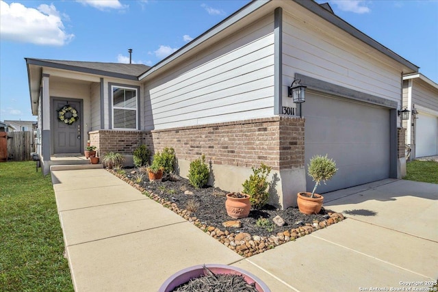 ranch-style house with a front yard, concrete driveway, and brick siding