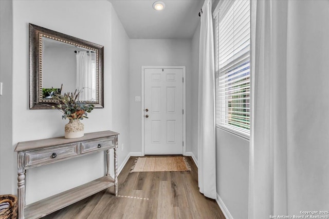 entryway with dark wood-style floors and baseboards