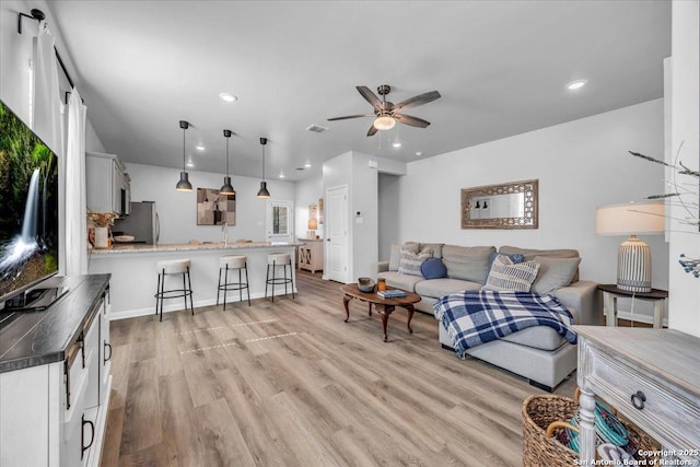 living area with light wood finished floors, baseboards, visible vents, a ceiling fan, and recessed lighting