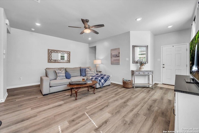 living room featuring baseboards, light wood-type flooring, a ceiling fan, and recessed lighting