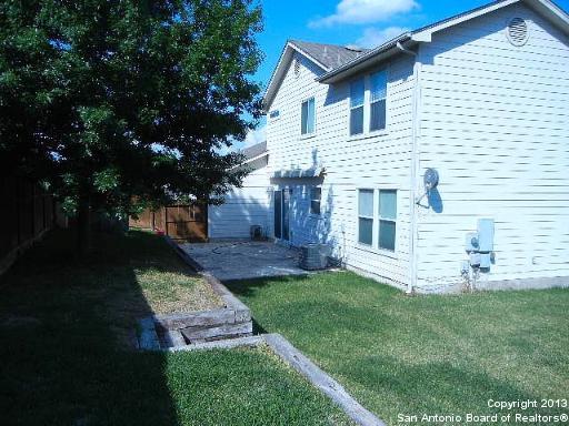 rear view of house with fence, a lawn, and a patio