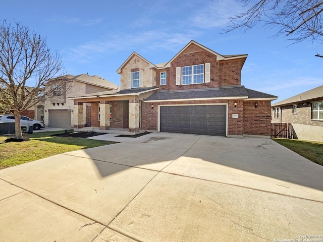 traditional-style home with a garage, brick siding, roof with shingles, and concrete driveway