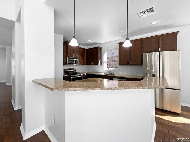 12518 Ponder, San Antonio, TX 78245 - kitchen with visible vents, dark brown cabinets, dark wood-type flooring, light stone countertops, and stainless steel appliances