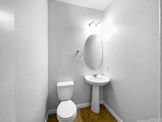 12518 Ponder, San Antonio, TX 78245 - bathroom featuring toilet, a textured wall, baseboards, and a sink