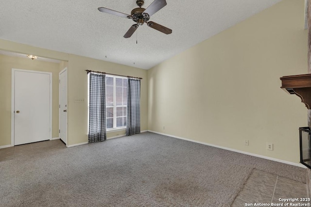 interior space with a textured ceiling, carpet flooring, and baseboards