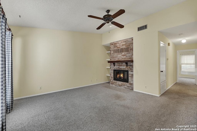 unfurnished living room featuring a textured ceiling, a fireplace, visible vents, baseboards, and carpet