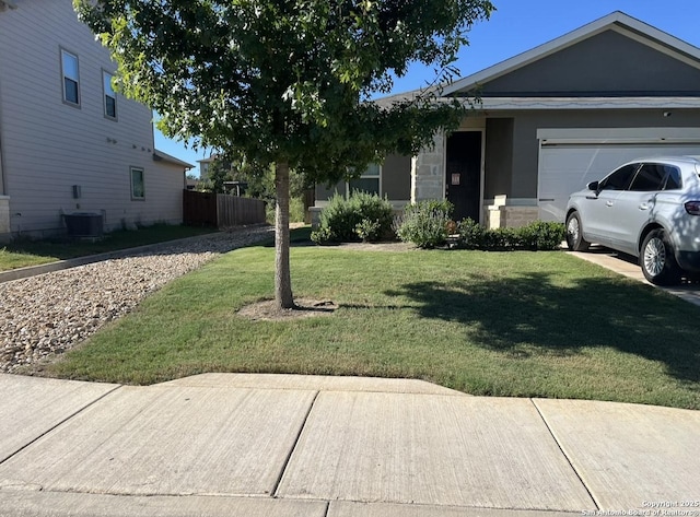 view of front of house featuring an attached garage, a front lawn, and cooling unit