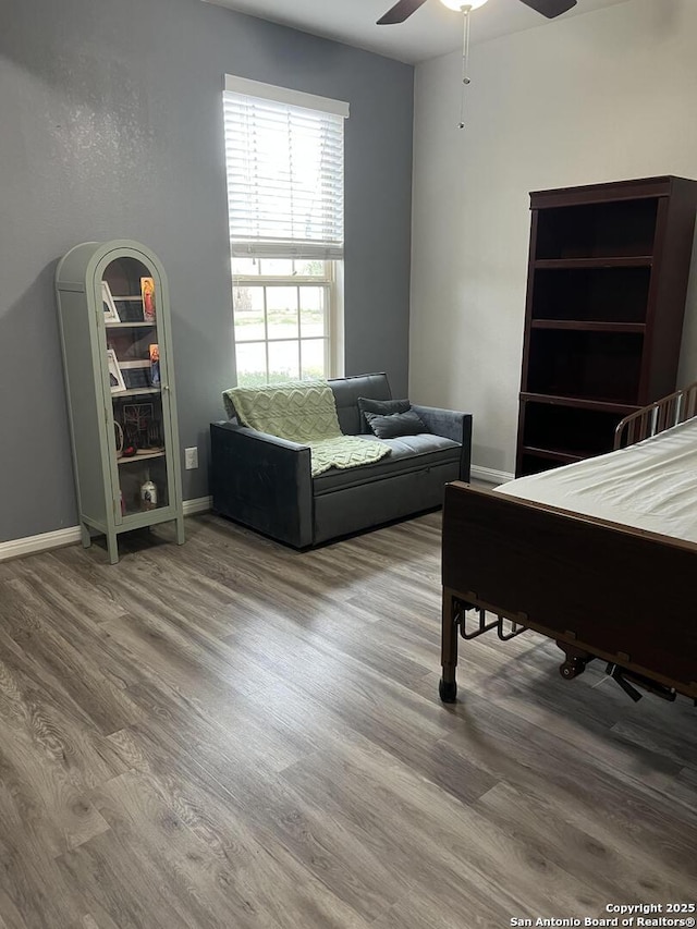 interior space with ceiling fan, wood finished floors, and baseboards