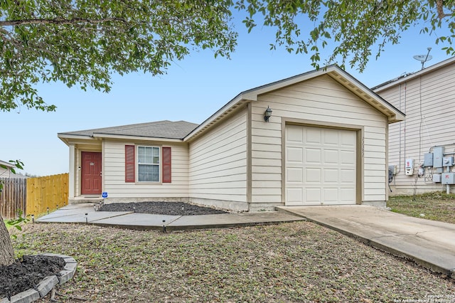 ranch-style home featuring a garage, fence, and driveway