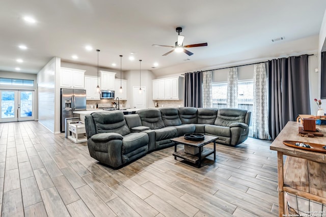 living area with ceiling fan, french doors, light wood-style flooring, and visible vents