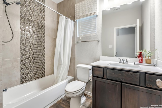 full bath featuring visible vents, toilet, wood finished floors, shower / bath combination with curtain, and vanity