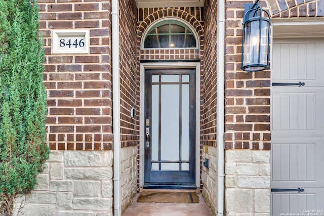 doorway to property featuring brick siding