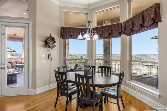 dining room featuring a chandelier, plenty of natural light, and wood finished floors