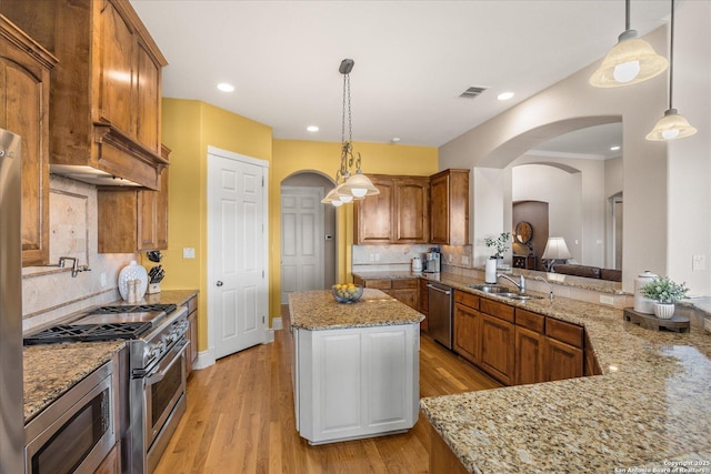 kitchen featuring arched walkways, appliances with stainless steel finishes, a sink, and visible vents