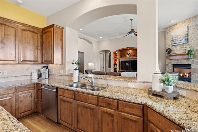 kitchen featuring light wood-type flooring, light stone countertops, and a sink