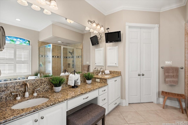 bathroom featuring tile patterned flooring, a sink, double vanity, a stall shower, and crown molding