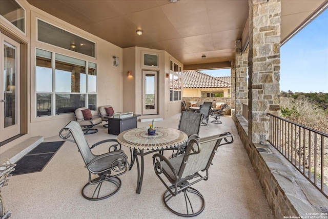 view of patio featuring outdoor dining area and a balcony