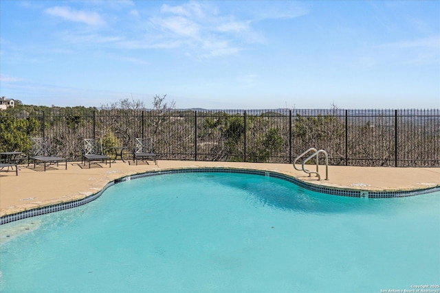 pool with a patio and fence