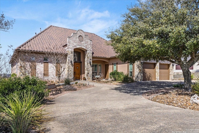 view of front of house featuring aphalt driveway, a garage, a tiled roof, stone siding, and stucco siding