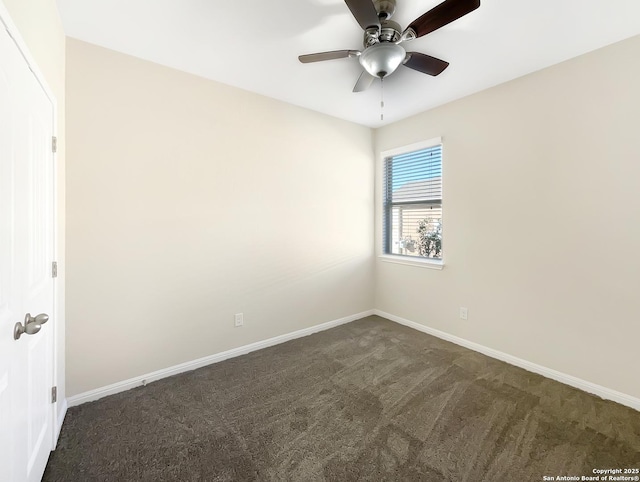 spare room featuring baseboards, dark carpet, and a ceiling fan