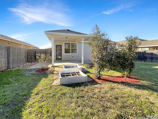 back of house with a patio area, a lawn, and a fenced backyard