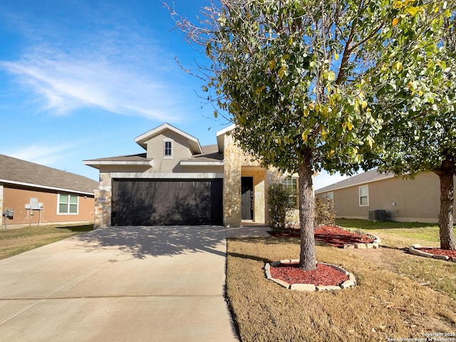 view of front of property with driveway, stone siding, an attached garage, central AC, and stucco siding