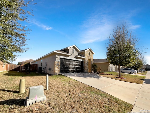 view of front of property with concrete driveway, a front yard, central AC, fence, and a garage