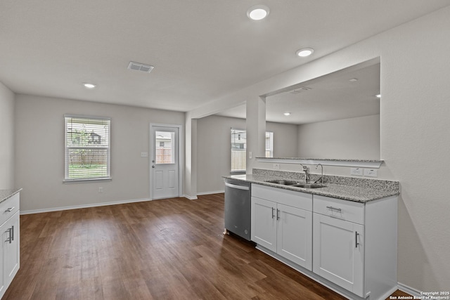 kitchen featuring dark wood-type flooring, a sink, visible vents, white cabinets, and dishwasher