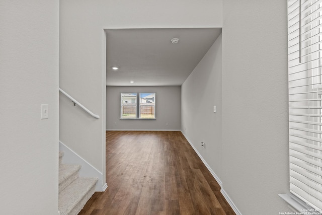 interior space with baseboards, stairway, and dark wood-style flooring