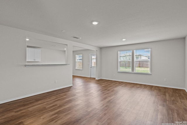 empty room featuring dark wood-type flooring, recessed lighting, visible vents, and baseboards