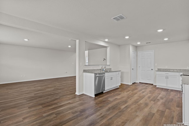 kitchen with visible vents, open floor plan, stainless steel dishwasher, white cabinetry, and a sink