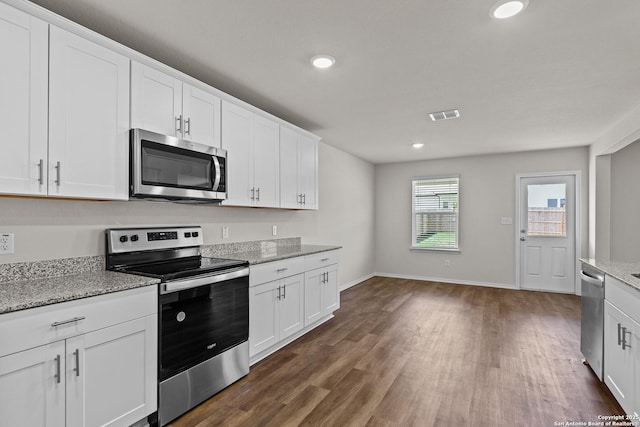 kitchen with visible vents, white cabinets, appliances with stainless steel finishes, dark wood-type flooring, and light stone countertops