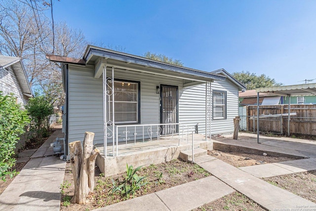 bungalow-style home featuring covered porch and fence