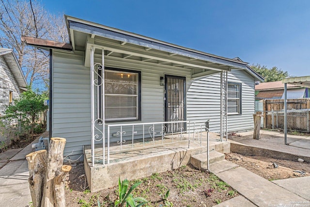 view of front of property with covered porch and fence