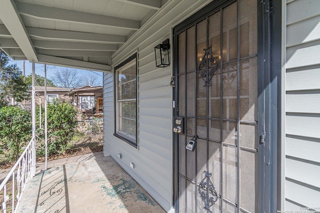 view of exterior entry featuring covered porch